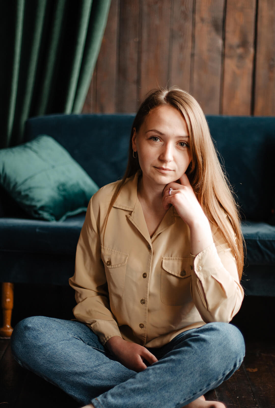 Woman sitting on a dark green couch with a thoughtful expression, symbolizing reflection and support during separation and divorce — Resolve Divorce Adelaide family law.