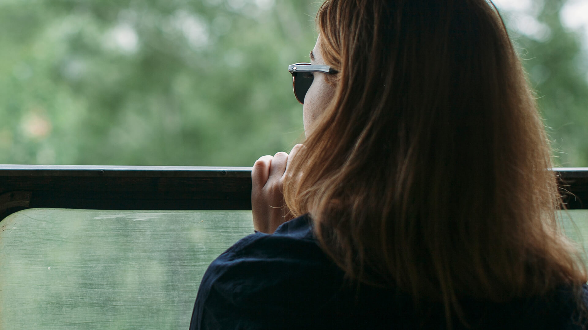 Woman looking out a window with trees in the background, symbolizing reflection and support during spousal maintenance discussions — Resolve Divorce Adelaide family law firm.
